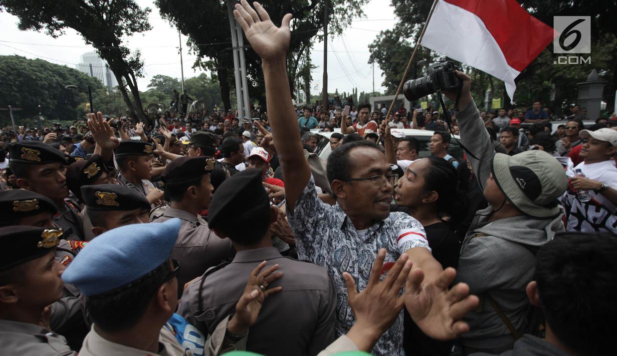 Demonstran driver online saling dorong dengan pihak kepolisian saat unjuk rasa di depan Istana Negara, Jakarta, Rabu (14/2). Kericuhan nyaris terjadi lantaran demonstran mencegat para driver online yang masih beroperasi. (Liputan6.com/Arya Manggala)