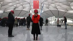 Seorang wanita berbicara di teleponnya di terminal Bandara Internasional Daxing Beijing di pinggiran Beijing, China (1/3). Pembangunan terminal bandara ini menghabiskan dana hingga 12 miliar dollar AS atau sekitar Rp 175 triliun. (AP Photo/Ng Han Guan)