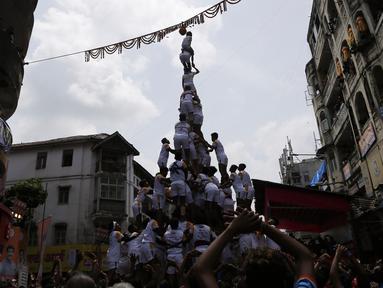 Umat Hindu membentuk piramida manusia untuk mencapai dan memecahkan dahi-handi (pot yang terbuat dari tanah liat) selama Festival Janmashtami di Mumbai, India pada 24 Agustus 2019. Festival ini menandai kelahiran dewa Krishna. (AP Photo/Rajanish Kakade)