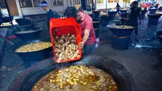 Para pria memasak hidangan kari tradisional yang disebut 'kuah beulangong' untuk dibagikan saat berbuka puasa, sekaligus memperingati turunnya Al-Quran selama bulan suci Ramadan, di Banda Aceh pada Sabtu 7 Maret 2026. Kuah Beulangong merupakan kuliner legendaris khas Aceh yang menjadi tradisi penting selama bulan Ramadan, terutama di wilayah Aceh Besar dan Banda Aceh. (CHAIDEER MAHYUDDIN/AFP)
