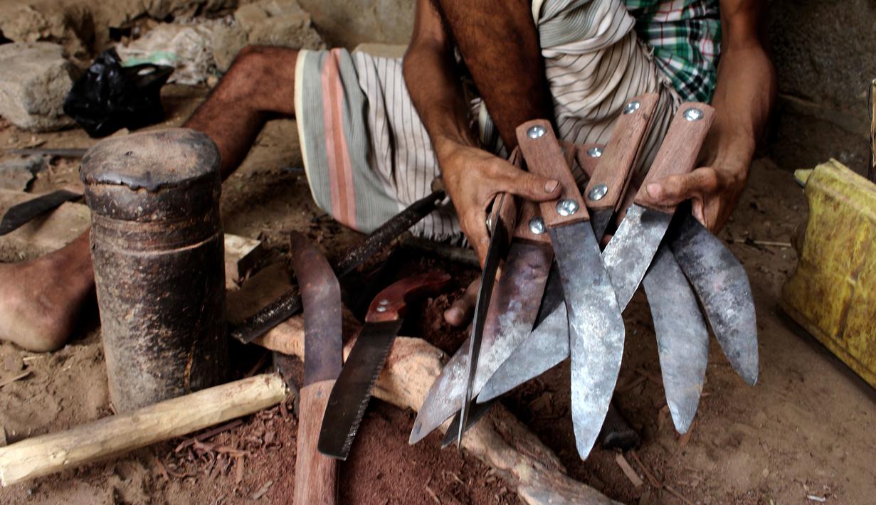 Foto 4 Agustus 2018, perajin membuat pisau tradisional, jambiya, dari sisa-sisa rudal di Hajjah, Yaman. Mereka mengumpulkan serpihan logam sisa-sisa dari rudal yang ditembakkan Koalisi Arab Saudi dan mengubahnya menjadi belati jambiya. (AP/Hammadi Issa)