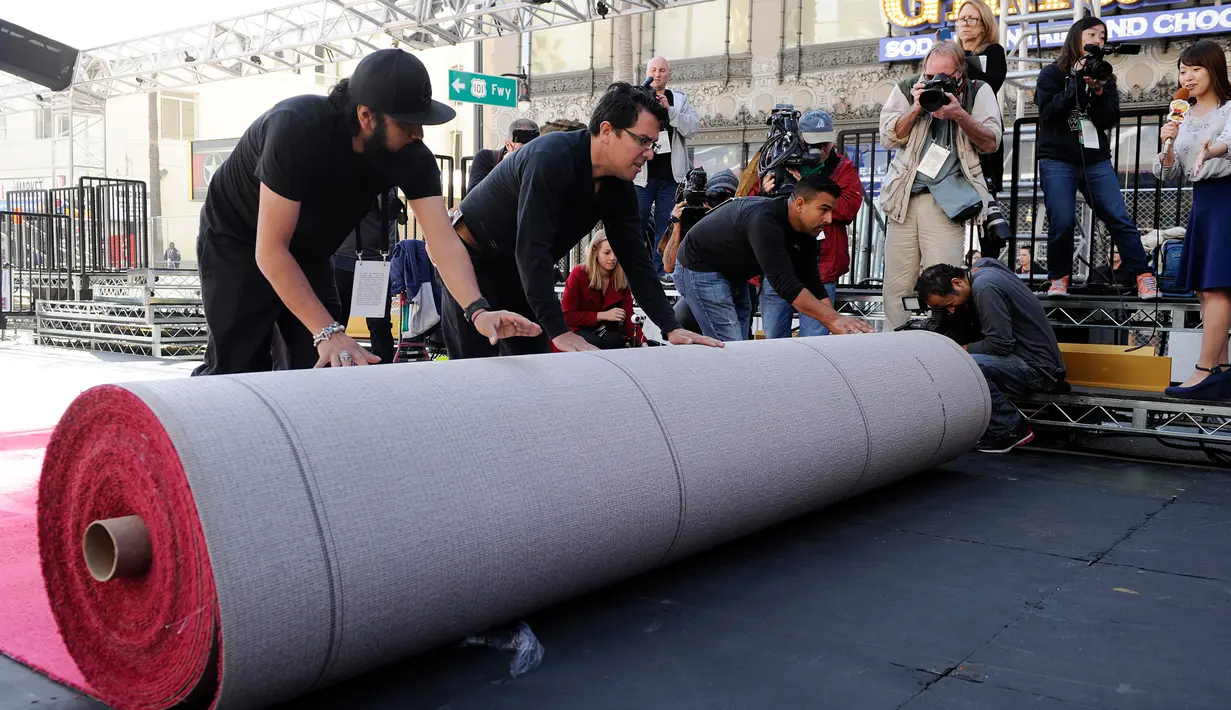 Pekerja menggelar karpet merah untuk ajang Academy Awards ke-89 di depan Dolby Theatre, Hollywood, Los Angeles, 22 Februari 2017. Penganugerahan Oscar 2017 akan diselenggarakan pada Minggu (26/2) waktu setempat. (Photo by Chris Pizzello/Invision/AP)