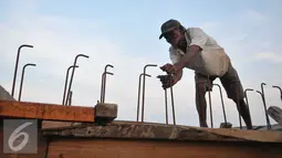 Pekerja menyelesaikan proyek pembangunan tanggul di Pantai Muara Baru, Jakarta, Rabu (2/12). Proyek pembangunan tanggul tersebut bertujuan untuk menahan banjir rob yang sering melanda kawasan Muara Baru. (Liputan6.com/Gempur M Surya)