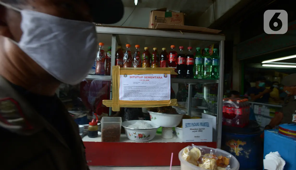 Segel penutupan sementara dipasang di salah satu tempat makan di Pasar Pramuka, Jakarta, Kamis (24/9/2020). Upaya mencegah penularan virus corona terus dilakukan dengan merazia penggunaan masker dan tempat usaha makan yang masih melayani makan di tempat. (merdeka.com/Imam Buhori)