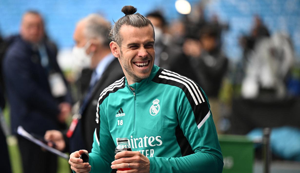 <p>Striker Real Madrid, Gareth Bale tersenyum saat menghadiri sesi latihan tim di Stadion Etihad di Manchester, Inggris barat laut, pada 25 April 2022. Real Madrid akan bertanding melawan Manchester City pada leg pertama semifinal Liga Champions. (AFP/Oli Scarff)</p>