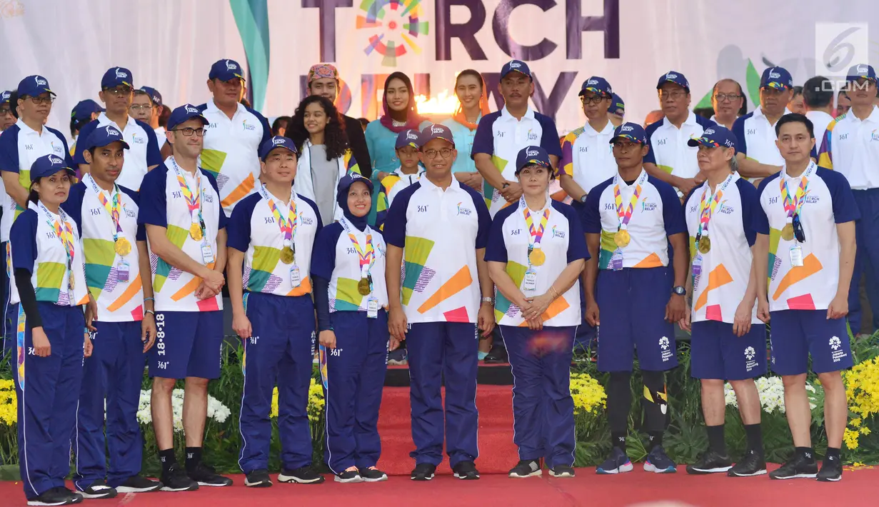Gubernur DKI Jakarta, Anies Baswedan foto bersama dengan pembawa obor dan jajaran Pemprov DKI Jakarta usai Api Obor Asian Games 2018 tiba di Balai Kota, Jakarta, Rabu (15/8). (Liputan6.com/Fery Pradolo)