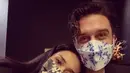 Potret menggemaskan, Adinia bersandar di bahu Michael. Keduanya mengenakan masker bermotif floral dan outfit bernuansa kehitaman. Foto: Instagram.