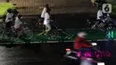 Pegiat bersepeda dan aktivis pecinta lingkungan saat aksi gowes Kelap Kelip Jakarta Night Ride #NOP26 di Jalan Jenderal Sudirman, Jakarta, Jumat (26/11/2021). Aksi ini mendorong pemimpin dunia berkomitmen meningkatkan tingkat bersepeda untuk mengurangi emisi karbon. (Liputan6.com/Helmi Fithriansyah)