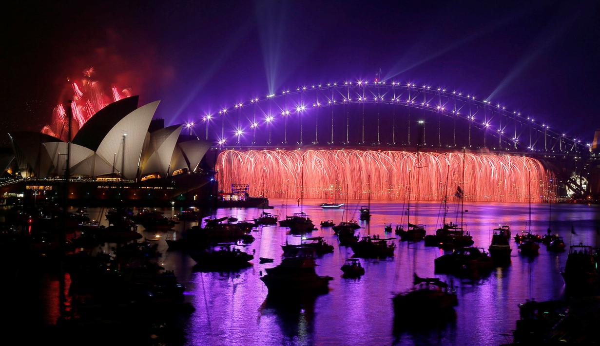 Warna-warni kemeriahan kembang api yang menghiasi Sydney Opera House dan Harbour Bridge, Sydney, Australia (31/12). Tempat tersebut merupakan salah satu tujuan para turis untuk menghabiskan malam pergantian tahun. (Reuters/Jason Reed)