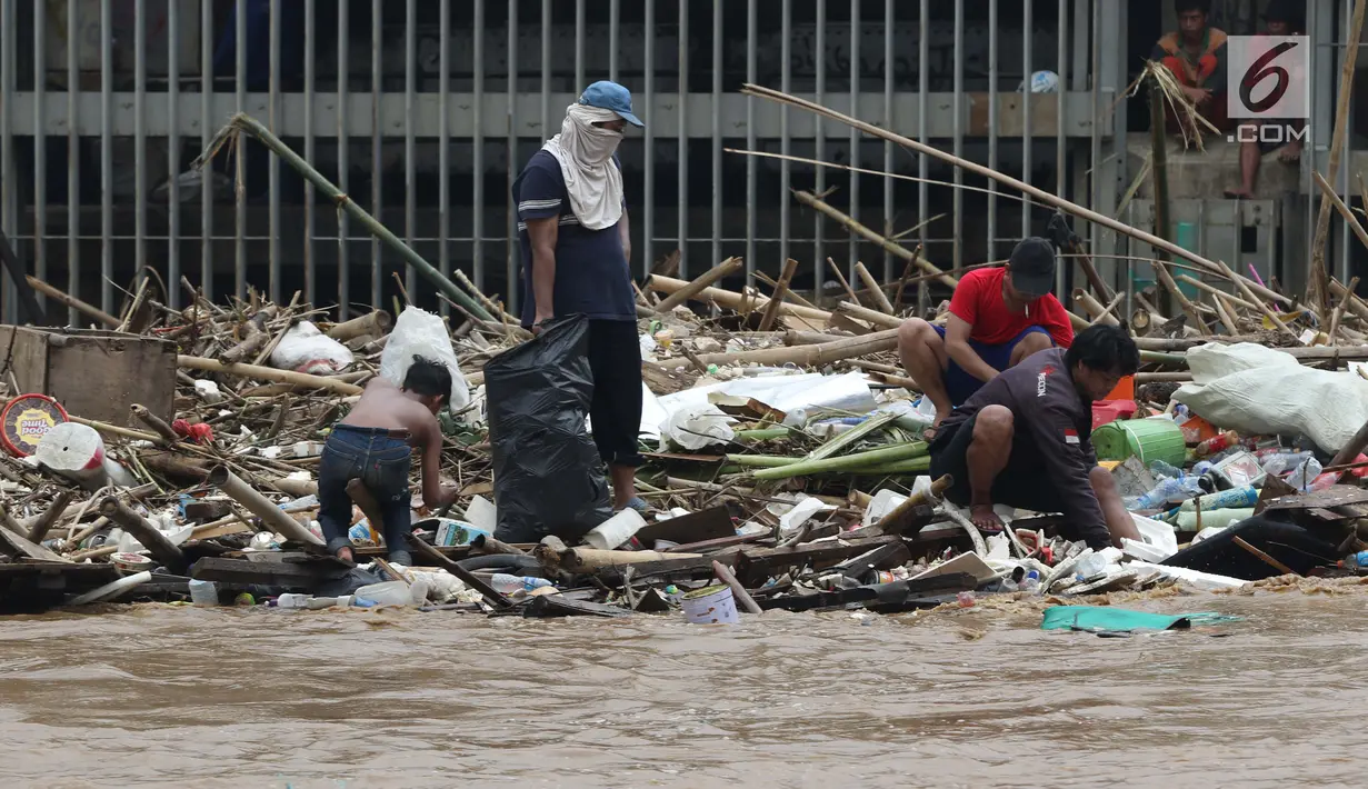 Pemulung bersama sejumlah anak mencari botol-botol plastik yang tersangkut diantara tumpukan sampah di Pintu Air Manggarai, Jakarta, Jumat (26/4). Sampah ini terbawa arus sungai Ciliwung akibat curah hujan yang tinggi di kawasan Bogor dan sekitarnya, Kamis (25/4). (Liputan6.com/Helmi Fithriansyah)