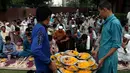 Relawan mendistribusikan makanan berbuka puasa atau iftar kepada muslim Pakistan di sebuah masjid di Lahore pada 7 Mei 2019. Ketika bulan Ramadan mulai di Pakistan, banyak masyarakat muslim memanfaatkan buka puasa gratis yang disponsori oleh badan-badan amal dan orang-orang kaya. (AP/K.M. Chaudary)
