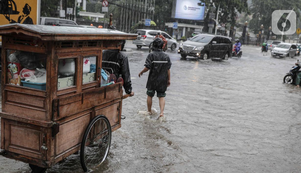 Kondisi genangan air di Jalan Medan Merdeka Timur, Jakarta, Jumat (24/1/2020). Hujan deras yang mengguyur Jakarta sejak pagi tadi mengakibatkan genangan air di Jalan Medan Merdeka Timur. (Liputan6.com/Faizal Fanani)