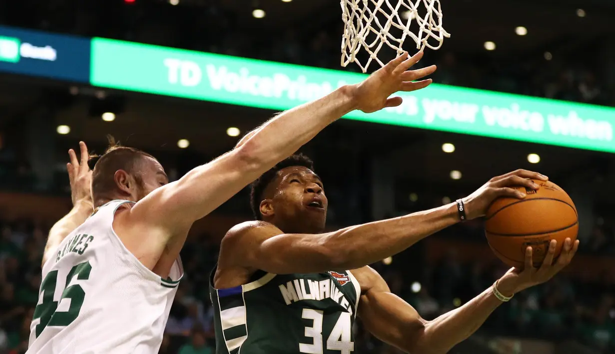 Pebasket Milwaukee Bucks, Giannis Antetokounmpo, menghindari hadangan pebasket Boston Celtics, Aron Baynes, pada laga NBA di TD Garden, Boston, Rabu (18/10/2017). Celtics kalah 100-108 dari Bucks. (AFP/Maddie Meyer)