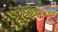 Petugas mengecek tabung LPG bersubsidi  yang diamankan di Jakarta, Jumat (15/7/2022). Sebanyak, 3.344 tabung gas non subsidi yang dijual di pasaran  sebagai barang bukti yang telah diamankan bersama 14 tersangka. (merdeka.com/Imam Buhori)