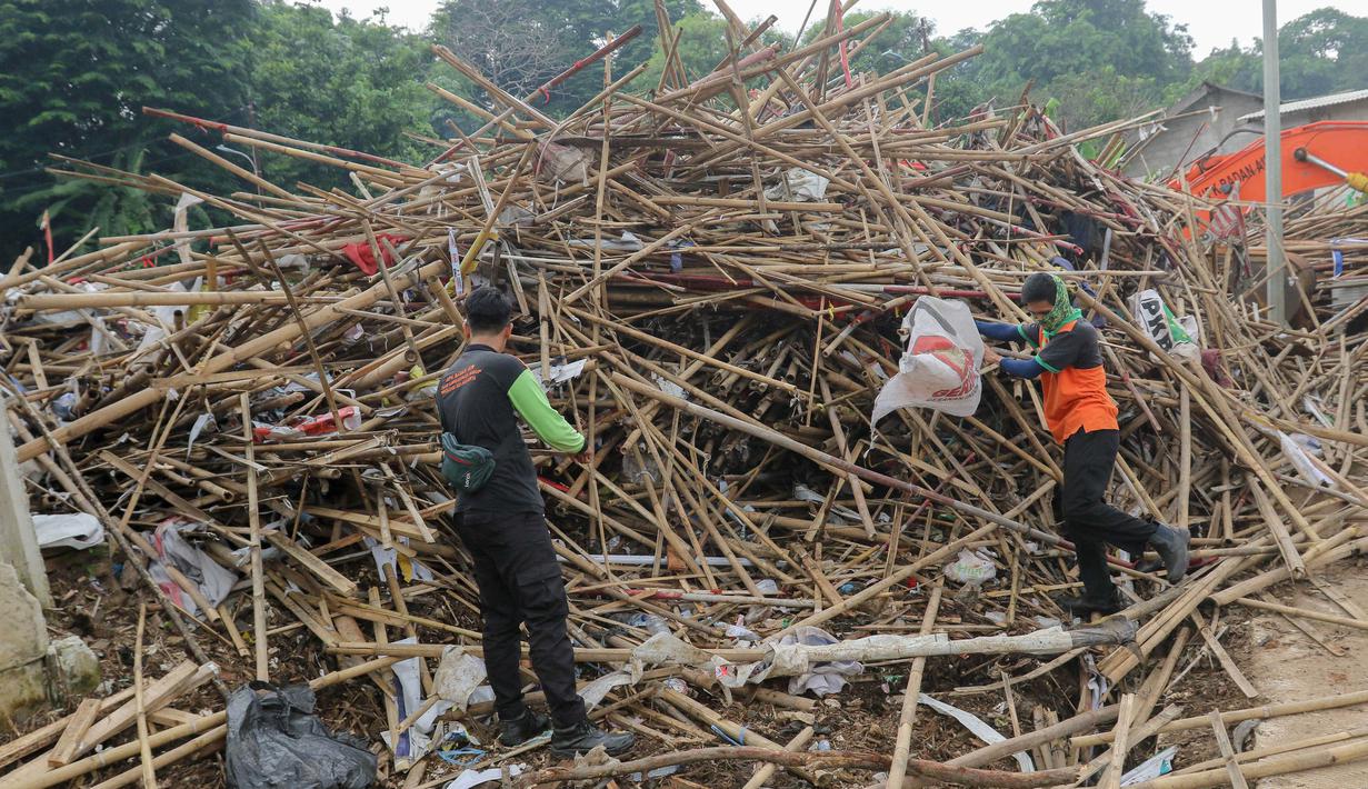 Petugas sedang memilah tumpukan bambu bekas sisa alat peraga kampanye di tempat penyaringan sampah di TB Simatupang, Jakarta, Jumat (16/2/2024). (Liputan6.com/Herman Zakharia)