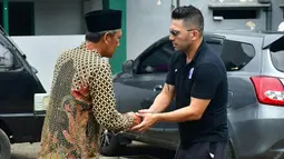 Pelatih Arema FC, Javier Roca menyalami kerabat salah seorang korban Tragedi Kanjuruhan yang merupakan putra pengasuh Pondok Pesantren Miftahul Ulum Atthohirin, Gondanglegi, Malang. (AFP/Putri)