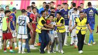 Petugas keamanan berhasil mengamankan seorang suporter yang masuk kedalam lapangan setelah laga FIFA Matchday antara Timnas Indonesia Vs Timnas Argentina di Stadion Utama Gelora Bung Karno (SUGBK), Senayan, Jakarta, Senin (19/06/2023). (Bola.com/M Iqbal Ichsan)