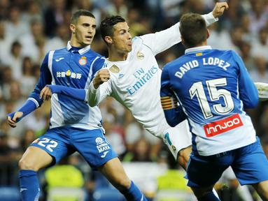 Bintang Real Madrid, Cristiano Ronaldo (tengah) melepaskan tembakan melewati adangan pemain Espanyol pada laga La Liga Santander di Santiago Bernabeu stadium, Madrid, (01/10/2017). Real Madrid menang 2-0. (AP/Paul White)