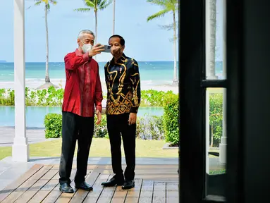 Setelah menyampaikan pernyataan pers bersama dan sebelum melakukan jamuan santap siang, Presiden Joko Widodo (kanan) dan PM Singapura Lee Hsien Loong berswafoto dengan latar belakang pantai di The Shancaya Resort Bintan, Bintan, Kepulauan Riau, Selasa (25/1/2022). (Laily Rachev/Biro Pers Setpres)