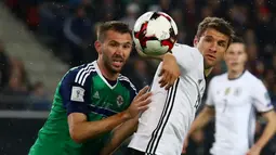 Striker Jerman, Thomas Muller (kanan), dijaga ketat pemain Irlandia Utara, Gareth McAuley, pada laga Grup C Kualifikasi Piala Dunia 2018 zona Eropa, di HDI-Arena, Hanover, Rabu (12/10/2016) dini hari WIB. (Reuters/Kai Pfaffenbach)