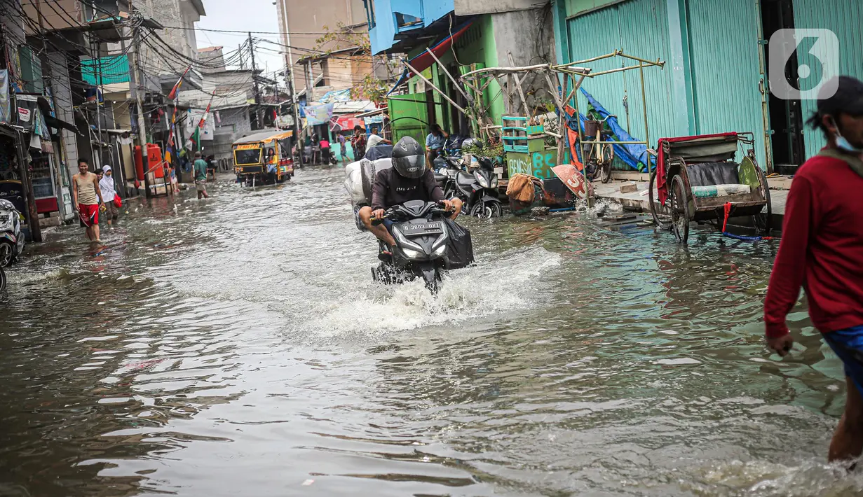 Pengendara sepeda motor menerjang banjir rob di Muara Angke, Jakarta, Jumat (25/11/2022). Badan Penanggulangan Bencana Daerah (BPBD) DKI Jakarta mengimbau agar warga di pesisir Jakarta mengantisipasi banjir pesisir atau rob selama 22-28 November 2022. (Liputan6.com/Faizal Fanani)
