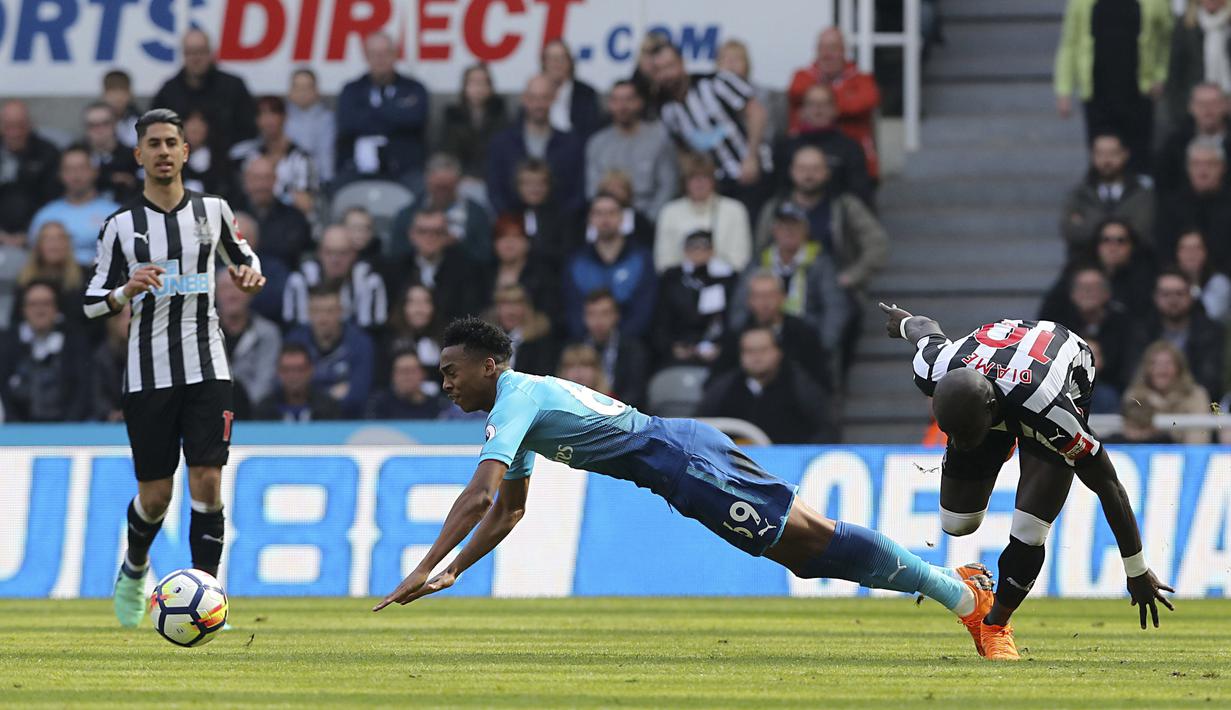 Pemain Arsenal, Joe Willock (kiri) jatuh saat berebut bola dengan pemain Newcastle United,  Mohamed Diame pada lanjutan Premier League di St James' Park, Newcastle, (15/4/2018). Newcastle menang 2-1. (Owen Humphreys/PA via AP)