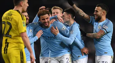 Pemain Manchester City, Kyle Walker dan Bernardo Silva merayakan gol ke gawang Burton Albion pada laga leg pertama semifinal Piala Liga Inggris di Stadion Etihad, Kamis (10/1). Manchester City menang telak atas Burton Albion 9-0. (Paul ELLIS/AFP)