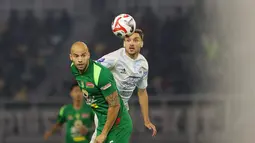 Pemain Persebaya, Risto Mitrevski berduel dengan pemain PSIM Yogyakarta, Nermin Haljeta pada pertandingan pembuka BRI Super League 2025/2026 di Stadion Gelora Bung Tomo, Jumat (08/08/2025) malam WIB. (Bola.com/Abdul Aziz)