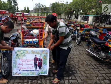 Sejumlah pria memasang spanduk di betor (becak motor) untuk persiapan arak-arakan ngunduh mantu Kahiyang-Bobby di Medan, Rabu (22/11). Ada 37 betor yang akan mengikuti pawai. (Liputan6.com/Johan Tallo)