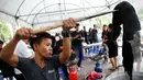 Seorang relawan sedang mewarnai pakaian agar menjadi hitam di Grand Palace di Bangkok, Thailand (17/10). Selama masa berkabung wafatnya raja Bhumibol Adulyadej warga Thailand mengenakan pakaian berwarna hitam.(Reuters/Edgar Su)