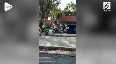 Seorang pengendara motor mencoba menghindari razia polisi dengan zig zag dan meliuk-liukan motornya.