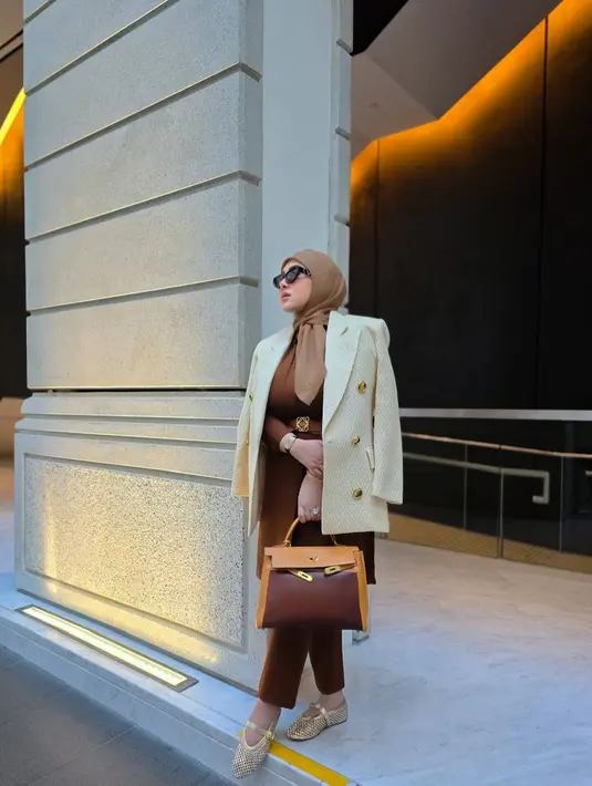 Terbaru, pelantun “Sesuatu” itu tampil serba coklat yang matching dengan stroller mewahnya.
Syahrini mengenakan blazer warna broken white yang dipadukan dengan one set warna coklat dan belt dari Loewe Anagram Wide in tan and gold berharga Rp10,6 juta.  [@princessyahrini].