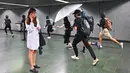 Seorang wanita memegang ponselnya ketika sejumlah demonstran bertopeng merusak Stasiun Diamond Hill di Distrik Kowloon, Hong Kong, Senin (7/10/2019). Demonstran bertopeng merusak beberapa stasiun MTR di Hong Kong. (Philip FONG/AFP)