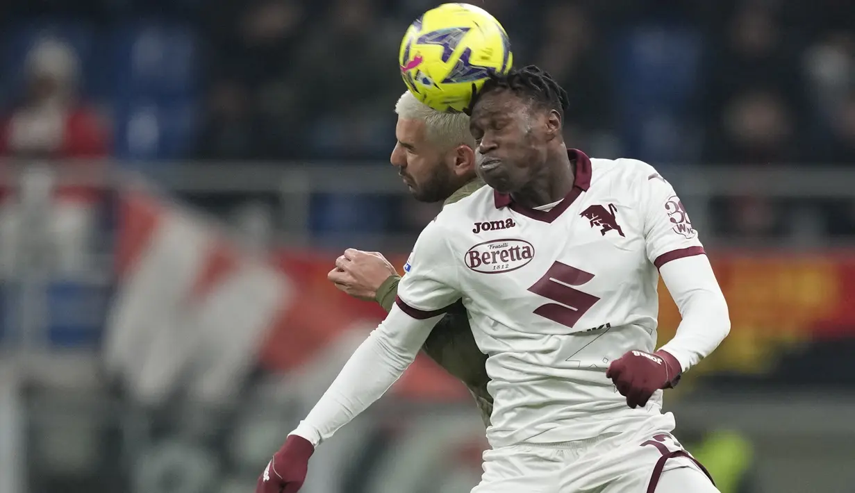 Bek Torino Wilfried Singo melompat untuk melakukan sundulan dengan bek  AC Milan Theo Hernandez dalam duel pekan ke-22 Serie A 2022-2023, Sabtu (11/2/2023) dini hari WIB. Sebelumnya, Milan mengalami tiga kekalahan dan dua hasil imbang. (AP Photo/Antonio Calanni)