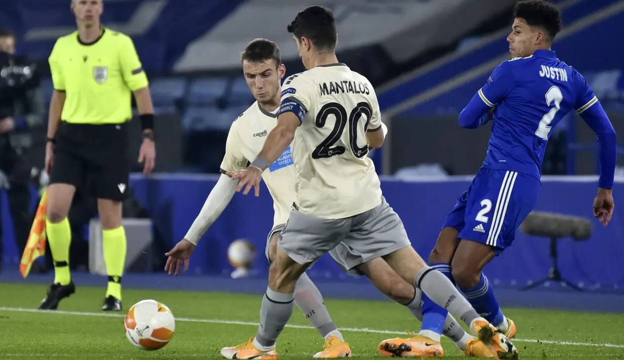 Bek Leicester City, James Justin berebut bola dengan gelandang AEK Athens, Petros Mantalos pada pertandingan Grup G Liga Europa di King Power Stadium, Jumat (11/12/2020) dinihari WIB. Leicester City memastikan diri keluar sebagai juara Grup G berkat kemenangan 2-0 kala menjamu AEK Athens.  (AP Photo
