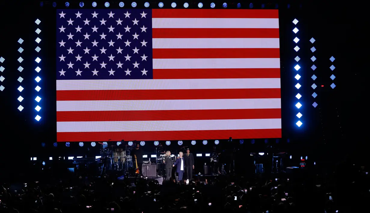 Penyanyi Beyonce dan suaminya, Jay Z berdiri bersama Capres AS Hillary Clinton seusai konser kampanye di Cleveland, Ohio, Jumat (4/11). Jay Z dan Beyonce menggelar konser bagi Hillary untuk meraih pemilih muda berkulit hitam di Ohio (AP Photo/Matt Rourke)
