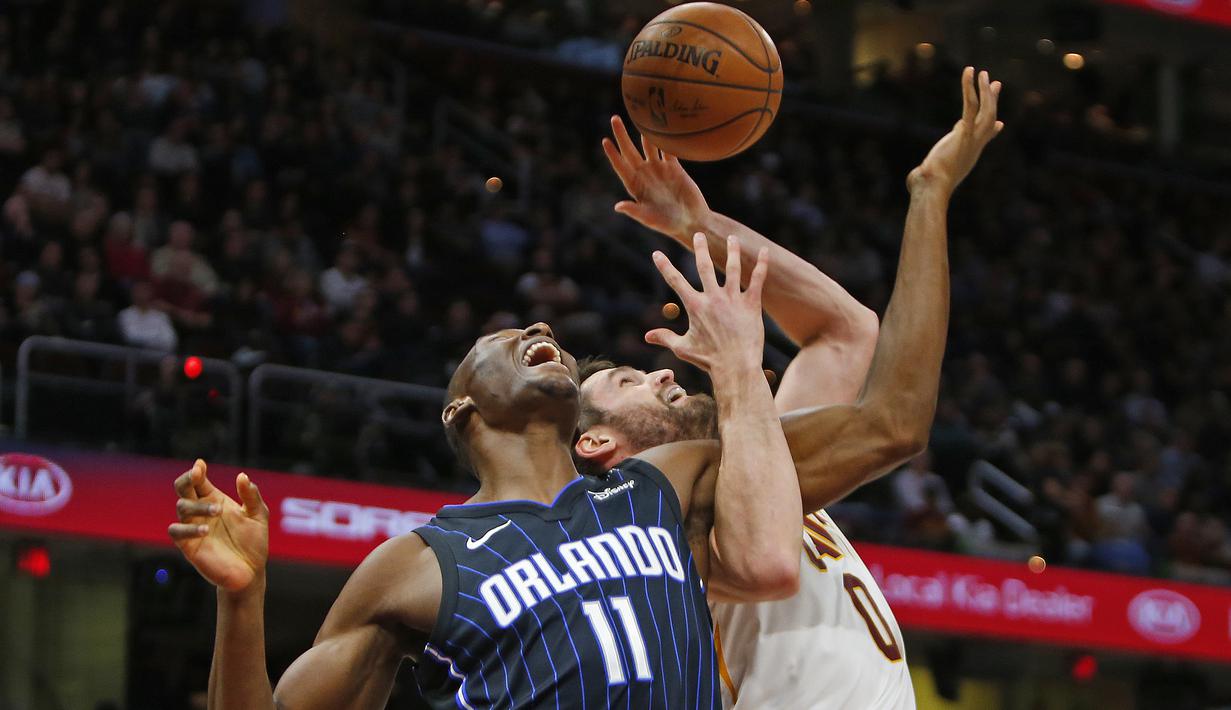 Pemain Orlando Magic Bismack Biyombo #11 dan pemain Cavaliers, Kevin Love #0 berebut bola pada lanjutan NBA basketball game di Quicken Loans Arena, (18/1/2018). Cavaliers menang 104-103. (Justin K. Aller/Getty Images/AFP)