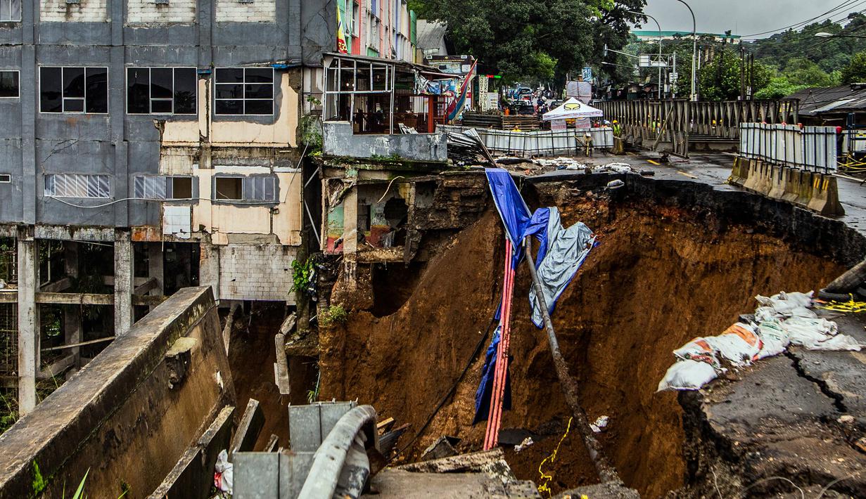 Fondasi bangunan pada tepi jurang terlihat pascalongsor akibat hujan deras di kawasan Caringin, Bogor, Jawa Barat, Kamis (2/32023). Jalan Nasional Bogor-Sukabumi tersebut sempat longsor hebat pada 27 Februari 2023. (ADITYA AJI/AFP)