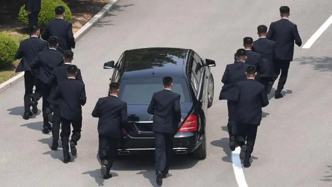 'Paspampres' mengawal mobil yang ditumpangi pemimpin Korea Utara Kim Jong-un. (AFP/Korea Summit Press Pool)