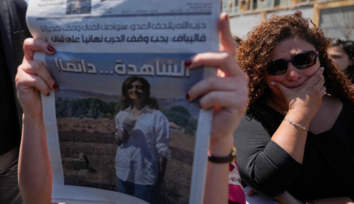 Amal Khalil dikenal sebagai jurnalis yang gigih melaporkan situasi di Lebanon selatan, wilayah yang sering menjadi titik panas konflik. Tampak dalam foto, seorang jurnalis bereaksi sementara lainnya memegang koran dengan potret jurnalis Lebanon Amal Khalil yang tewas dalam serangan udara Israel pada Rabu 22 April 2026, selama aksi duduk menentang penyerangan terhadap jurnalis di Beirut, Lebanon, Kamis 23 April 2026. (AP Photo/Hussein Malla)