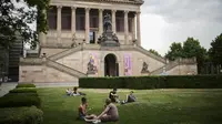 Orang-orang beristirahat pada hari musim panas di sebuah taman di depan museum Alte Nationalgalerie di Berlin, Jerman, Minggu (19/6/2022). Orang-orang berbondong-bondong ke taman dan kolam renang di seluruh Eropa Barat untuk sedikit mendinginkan tubuh mereka dari gelombang panas awal. (AP Photo/Markus Schreiber)