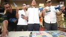 Petugas menunjukkan kartu ATM dan buku tabungan yang menjadi barang bukti kasus penipuan di Mapolres Metro Jakarta Barat, Senin (14/8). Kasus ini diperkirakan menyebabkan kerugian hingga miliaran rupiah sejak 2014 lalu. (Liputan6.com/Immanuel Antonius)