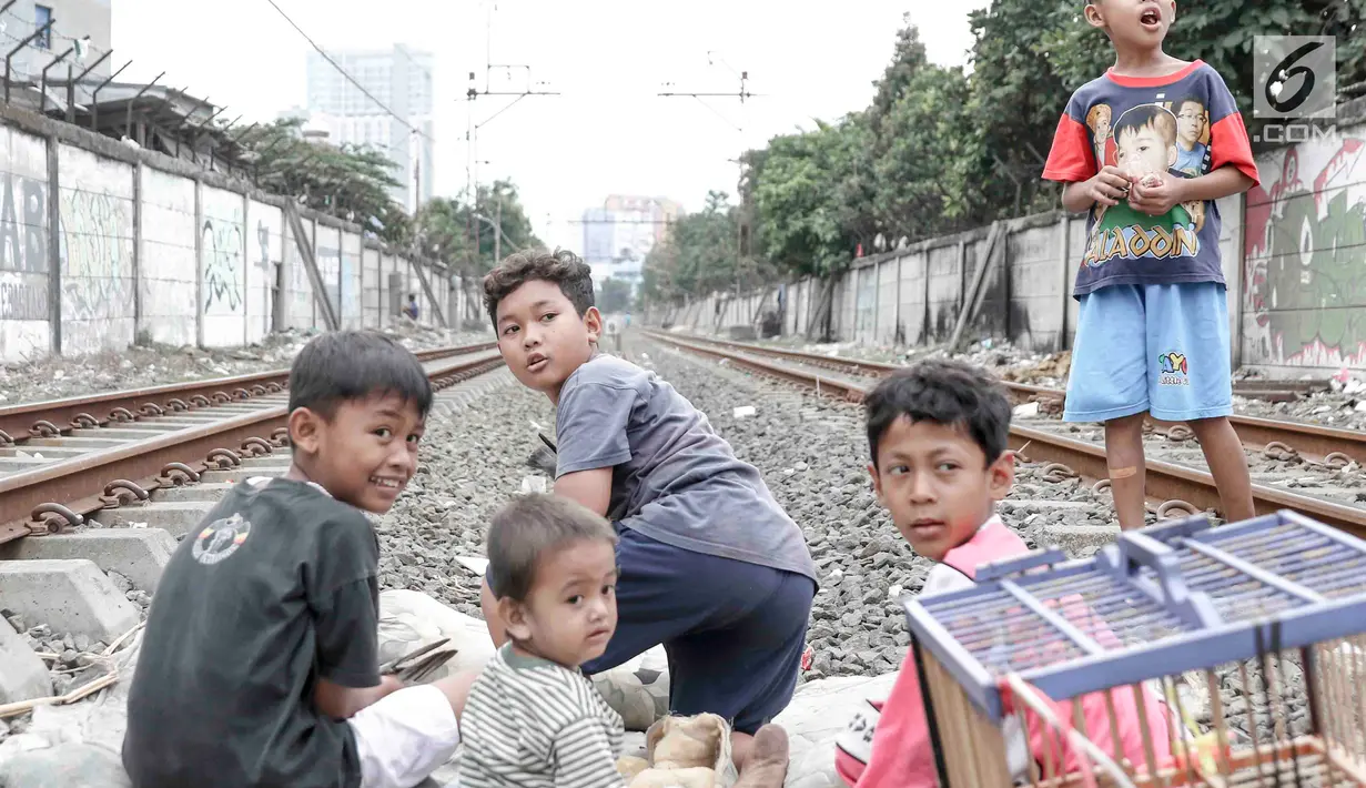 Anak-anak bermain di sekitar rel kereta api di kawasan Pademangan, Jakarta, Kamis (8/11). Kurangnya lahan bermain menyebabkan anak-anak tersebut bermain di tempat yang tidak semestinya dan membahayakan keselamatan. (Liputan6.com/Immanuel Antonius)