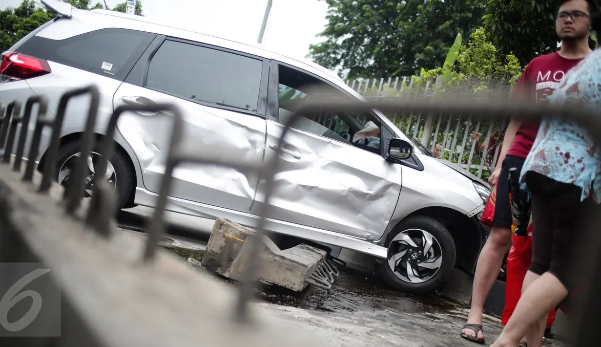 Sebuah mobil menabrak separator busway matraman arah kampung melayu, Jakarta, Sabtu (25/2). Diduga pengemudi kehilangan kendali yang akhirnya mengakibatkan menabrak separator busway. (Liputan6.com/Faizal Fanani)
