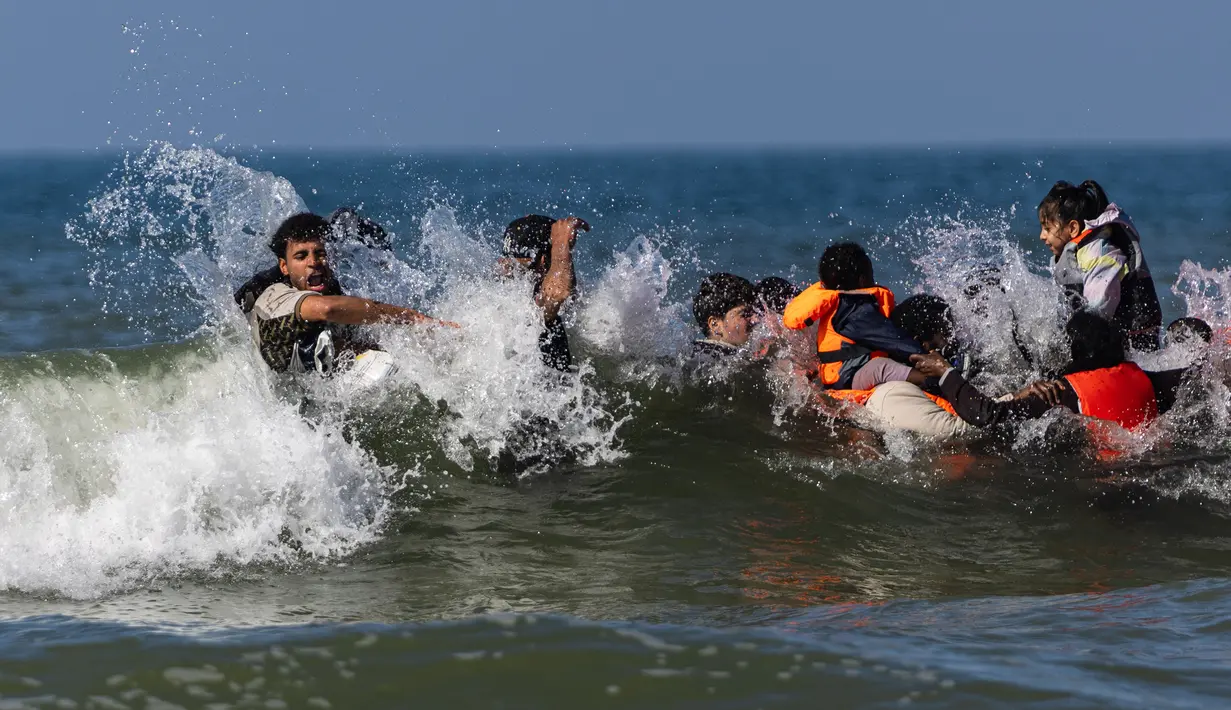 Migran berusaha menaiki perahu milik penyelundup dari pantai Equihen-Plage, Prancis utara, Rabu (23/9/2026), untuk menyeberangi Selat Inggris menuju Inggris. (Sameer Al-DOUMY/AFP)