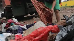 Warga memilah sampah sisa banjir yang menumpuk di kawasan Cipinang Melayu, Jakarta, Rabu (8/1/2020). Banjir yang melanda Jakarta dan sekitarnya sejak 1 Januari 2020 lalu menyisakan tumpukan sampah di sejumlah titik. (Liputan6.com/Herman Zakharia)
