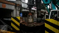 Alat berat membuat lubang untuk pemasangan tiang pancang proyek double-double track (DDT) Paket A Manggarai-Jatinegara, Jakarta, Minggu (26/3). Proses pengerjaan Paket A jalur Manggarai-Jatinegara terus di kebut. (Liputan6.com/Faizal Fanani)