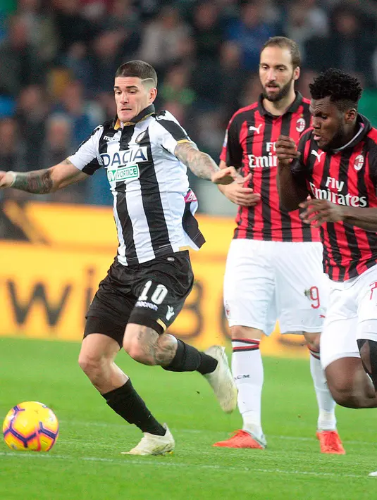 Gelandang AC Milan, Franck Kissie berusaha mengejar bola yang dibawa pemain Udinese, Rodrigo De Paul saat bertanding di Liga Italia di stadion Friuli Dacia Arena, Italia (4/11). Milan menang tipis atas Udinese 1-0. (AP Photo/Sefano Lancia)