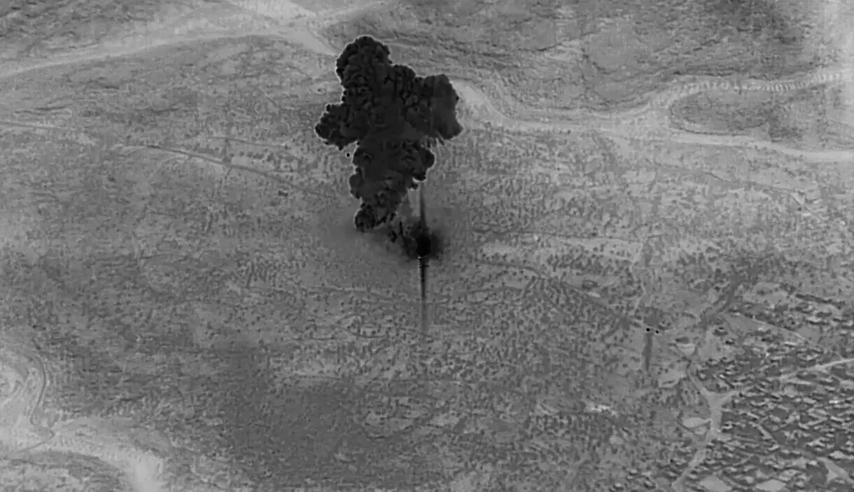 Gambar dari video yang dirilis Departemen Pertahanan AS pada 30 Oktober 2019 menunjukkan asap hitam membumbung saat penggempuran rumah persembunyian pemimpin ISIS Abu Bakr al-Baghdadi. Dua anak Baghdadi dipastikan tewas saat sang ayah meledakkan diri. (Department of Defense via AP)