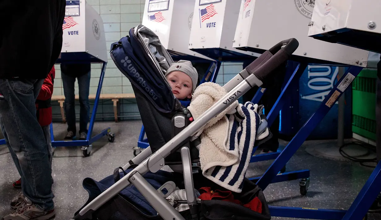 Seorang bayi saat berada di ruang tempat pemilihan presiden AS di New York City, AS, Selasa (8/11). Warga AS akan menentukan presiden mereka antara Hillary Clinton dan Donald Trump. (AFP Photo/ Drew Angerer)